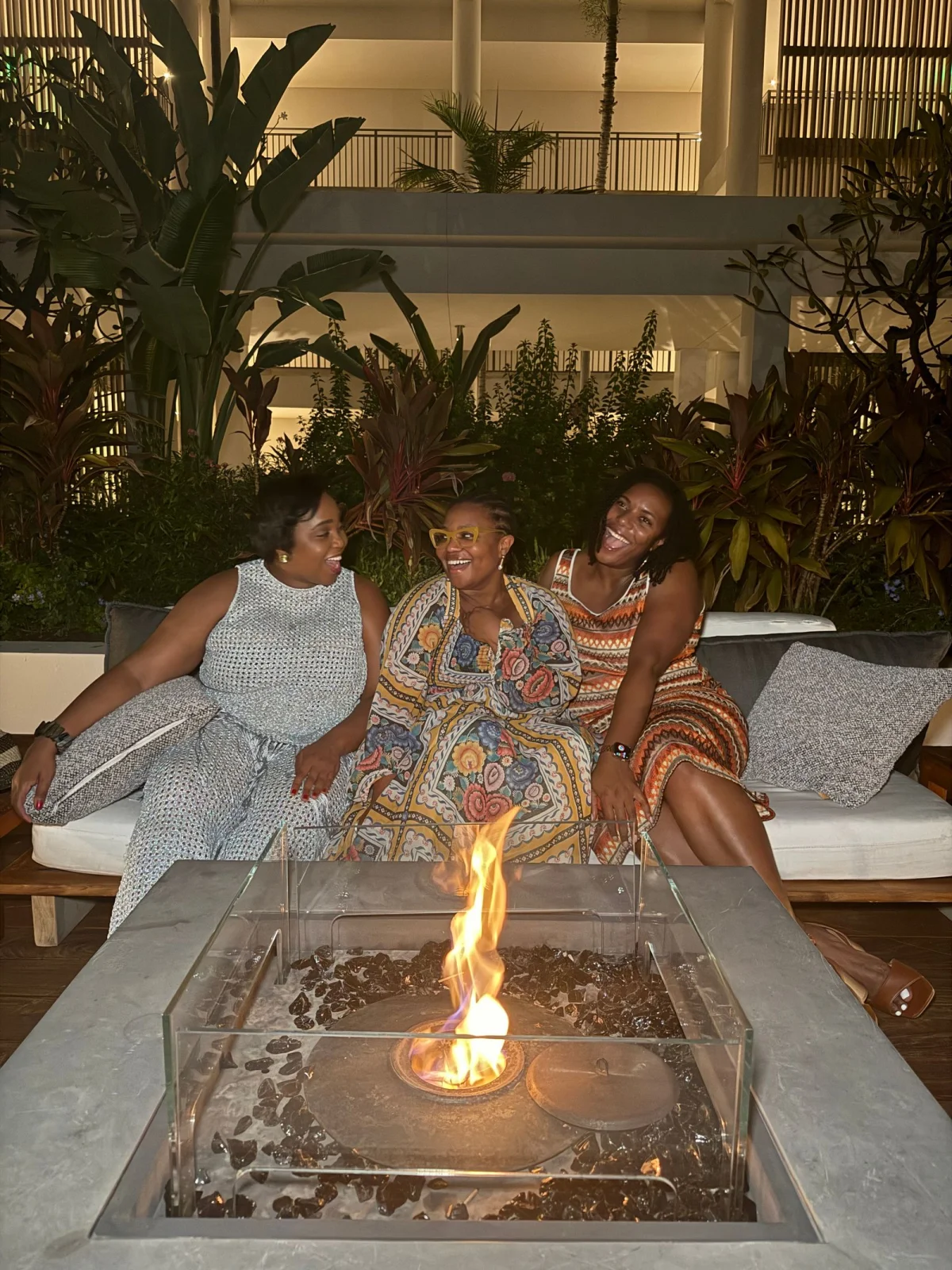 Three women talking beside a fire