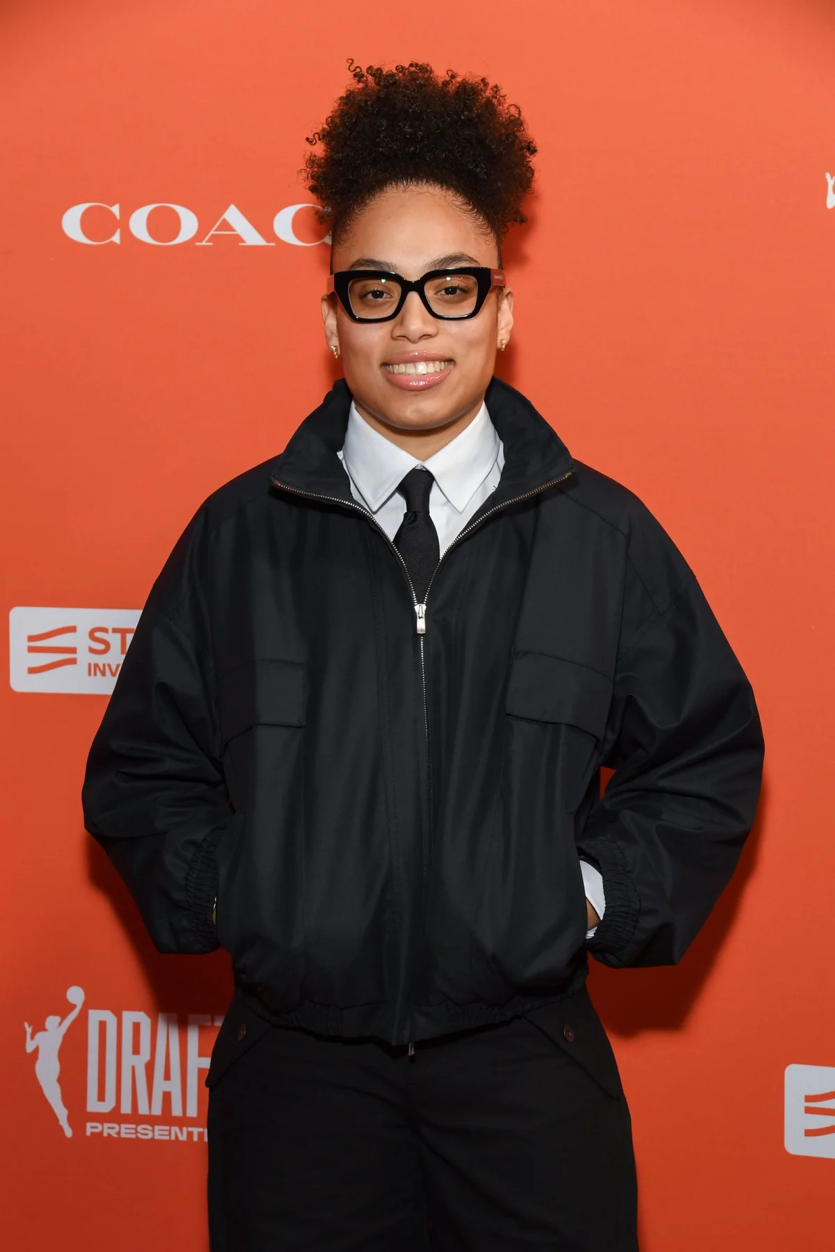 Image may contain Clothing Coat Jacket Adult Person Black Hair Hair Accessories Glasses Face Head and Photography